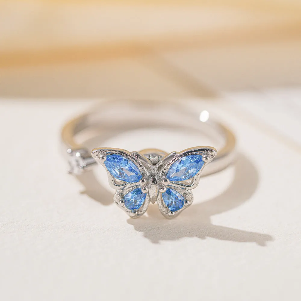 Butterfly adjustable ring with electroplated white gold finish and blue diamond accent on copper base