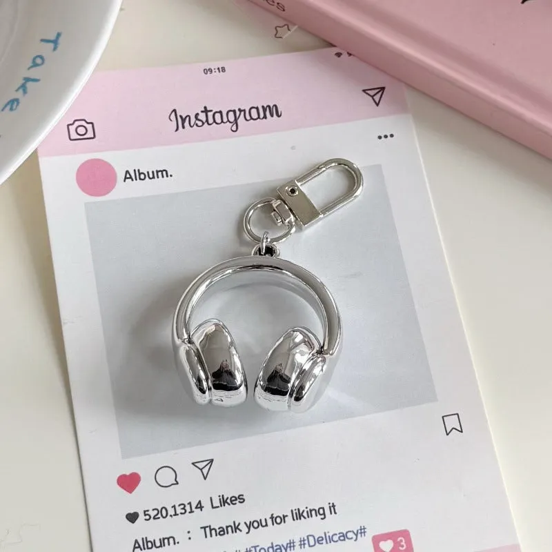 Small earphone pendant keychain with baking varnish finish in black on grey background