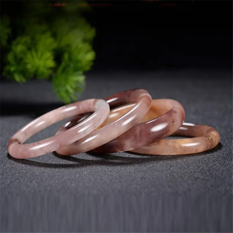 Violet jade bracelet with polished beads shown in flat bar and round bar styles on a wrist.
