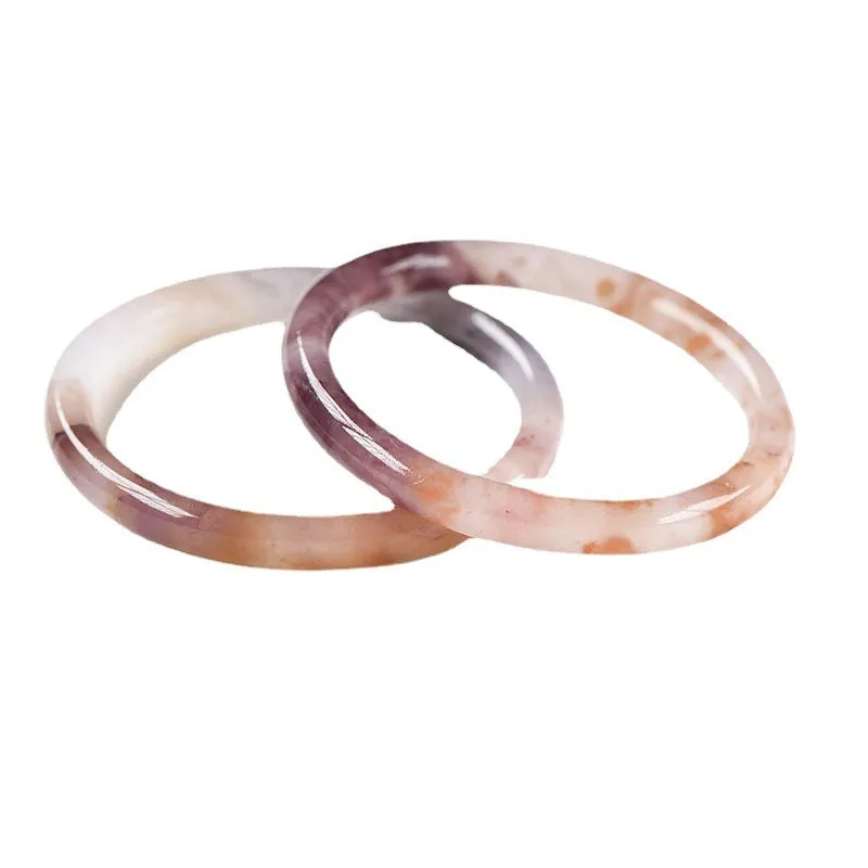 Violet jade bracelet with polished beads shown in flat bar and round bar styles on a wrist.