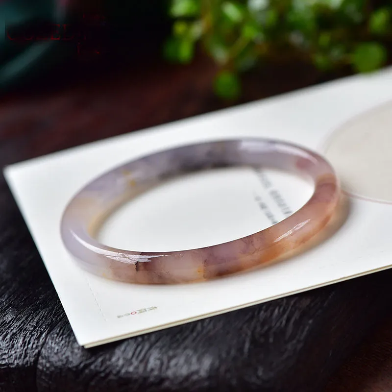 Violet jade bracelet with polished beads shown in flat bar and round bar styles on a wrist.