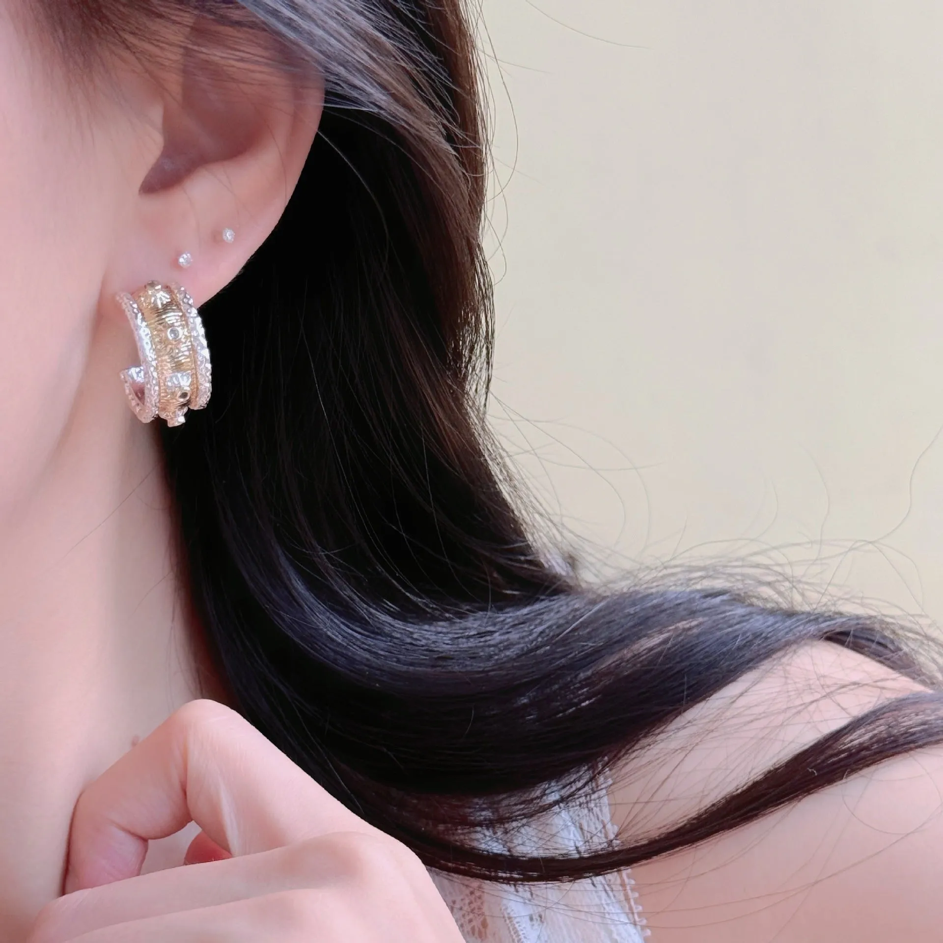 Gold and silver C-shaped brushed ring earrings on display, copper with 925 silver needles