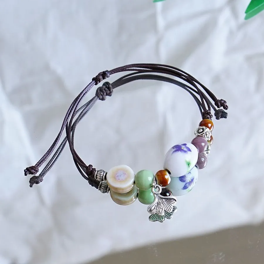 Women's ceramic braided bracelet with hand-woven cord and ceramic beads in traditional Chinese pattern