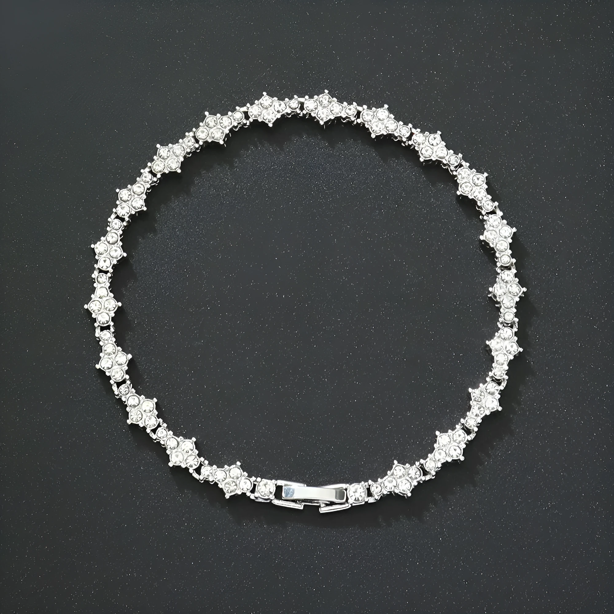 Flower-shaped cross tennis chain bracelet in gold alloy with diamond geometry pattern close-up