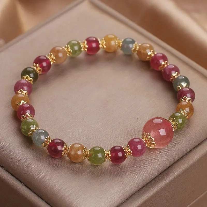 Close-up of a beaded bracelet with round strawberry quartz and tourmaline stones, 10mm in size.