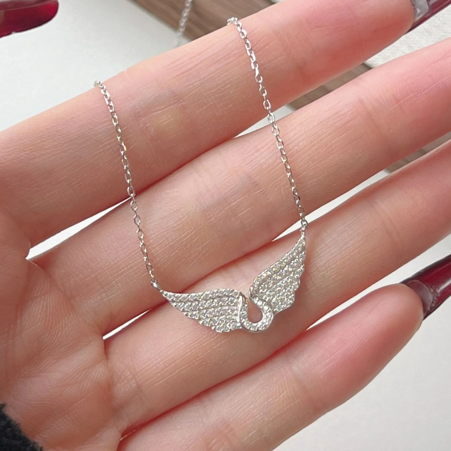 925 sterling silver wings fashion necklace on display with electroplated finish in white or yellow gold tone