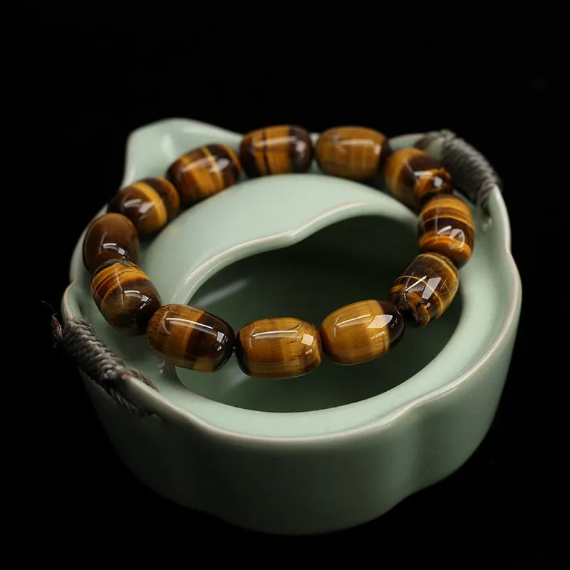 Yellow Tiger's Eye gemstone beaded bracelet with ethnic styling on a wrist.