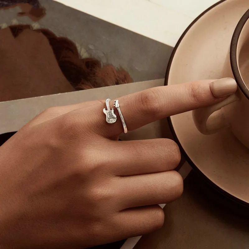 S925 silver oxidised open ring with guitar ornament on neutral background