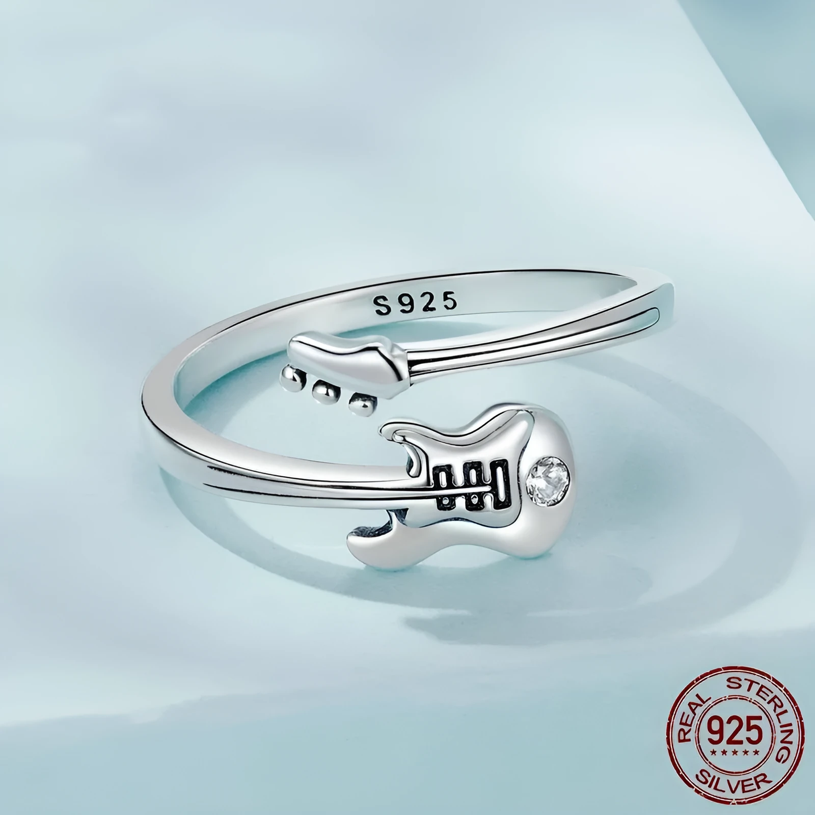 S925 silver oxidised open ring with guitar ornament on neutral background