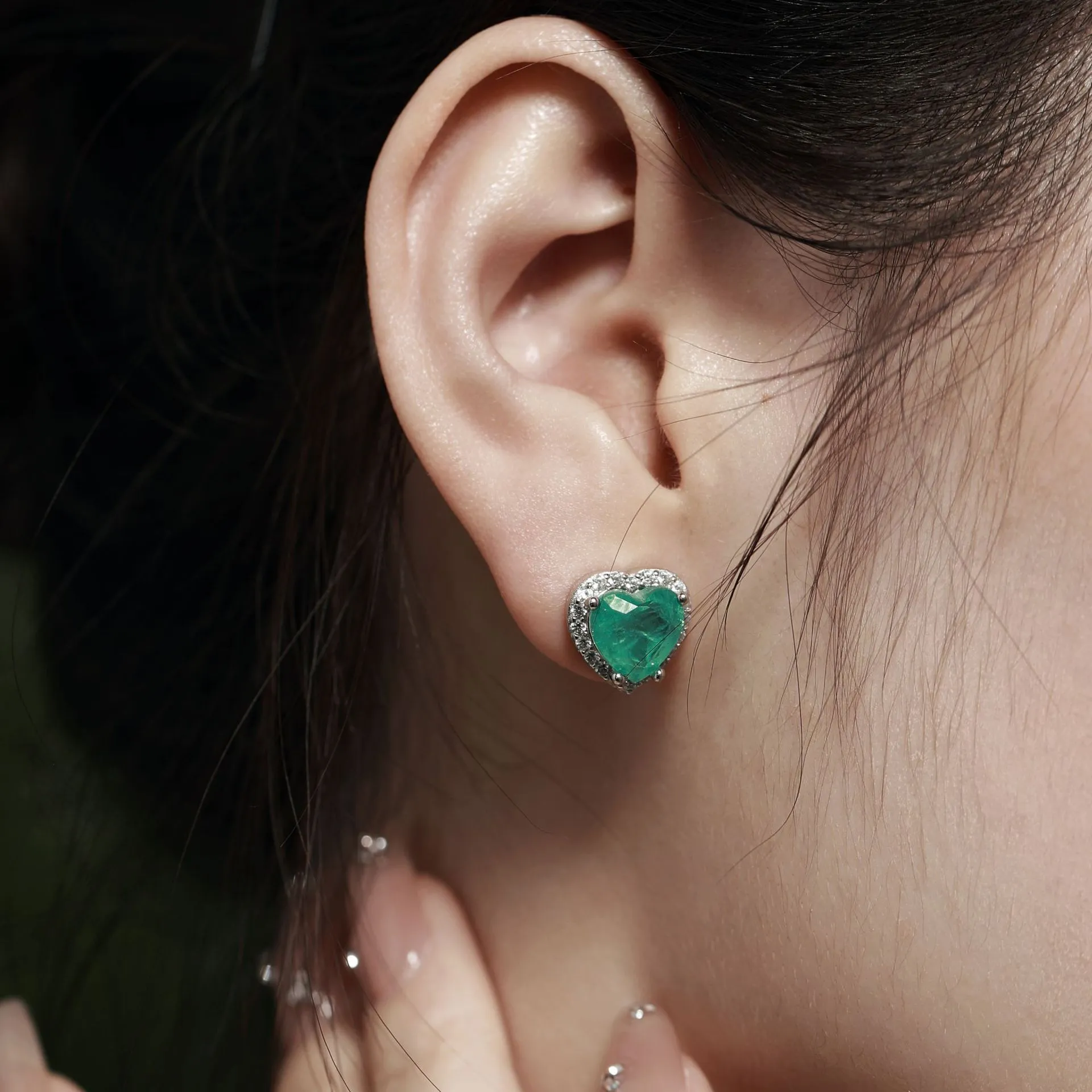 Green platinum 925 silver heart stud earrings on white background