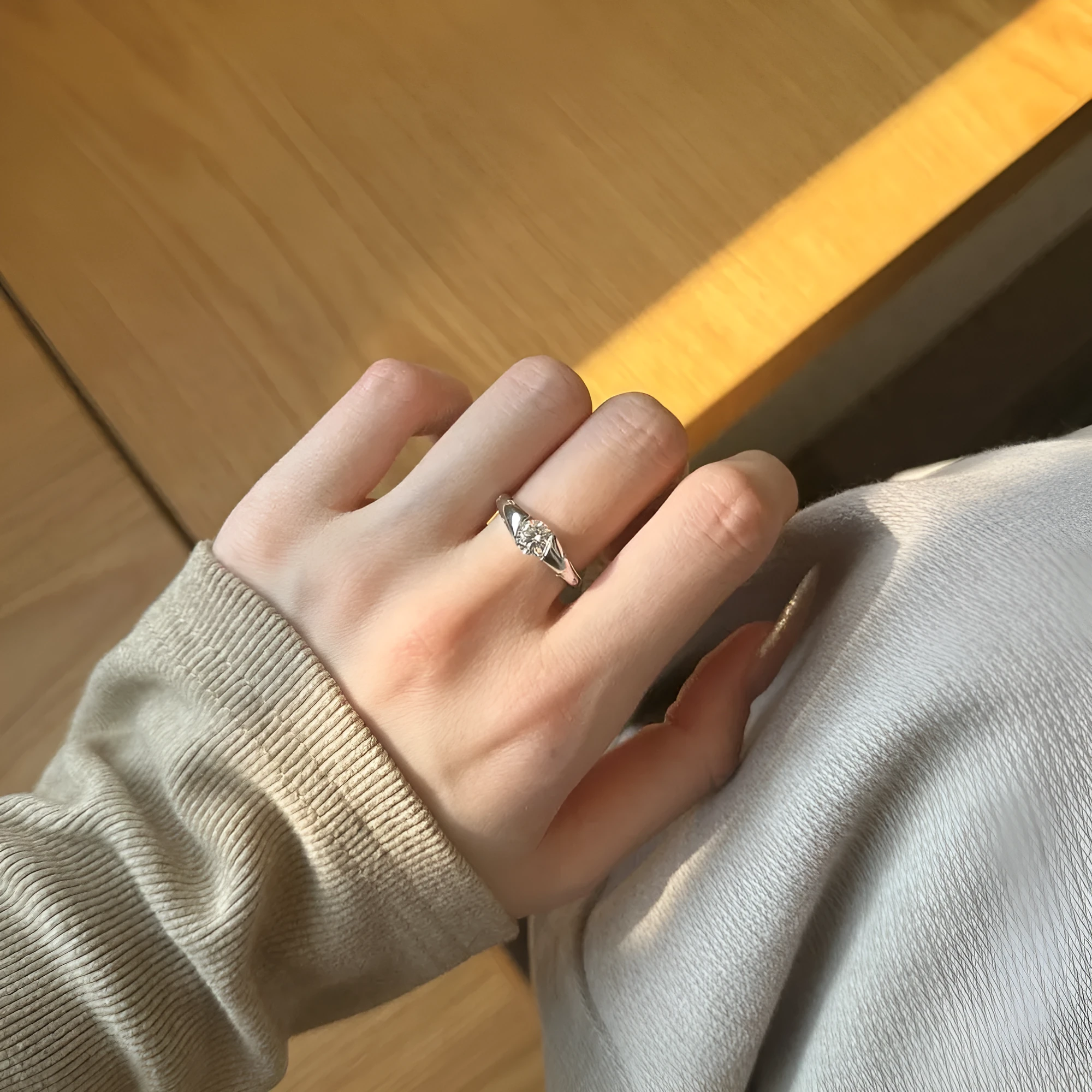 Silver round ring with glossy electroplated finish on display