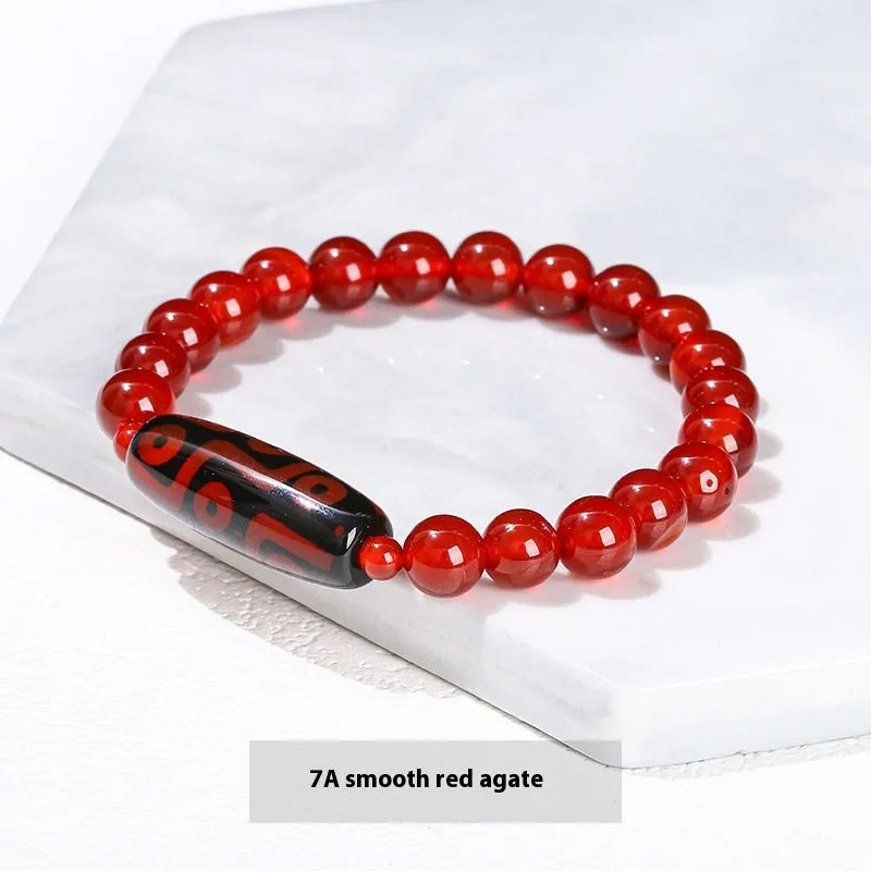 Handmade green dzi bead barrel bracelet with 8mm round geometric beads on a wrist.