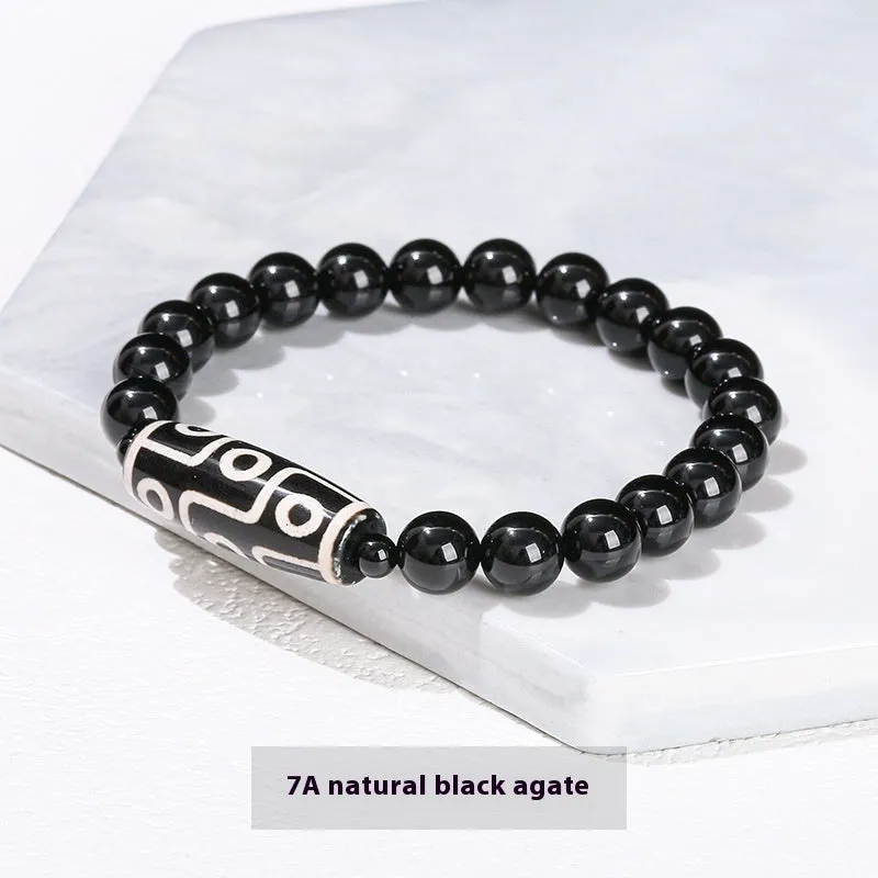 Handmade green dzi bead barrel bracelet with 8mm round geometric beads on a wrist.