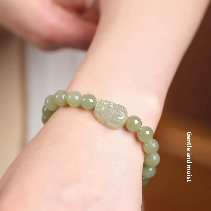 Grey Hetian jade ethnic style bracelet with polished beads on a wrist.