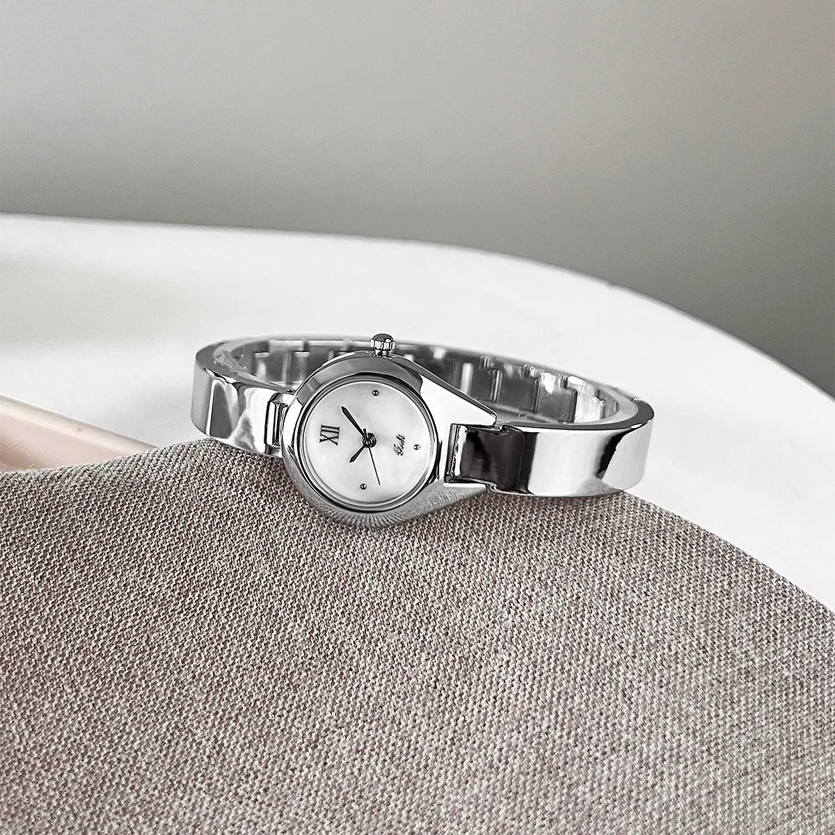 Women's quartz watch with 30mm white shell dial, silver hands, and white strap on display