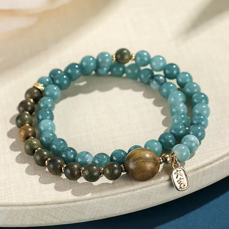 Close-up of a blue electroplated women's beaded bracelet with geometric and Fu/Xi character charms in New Chinese style.
