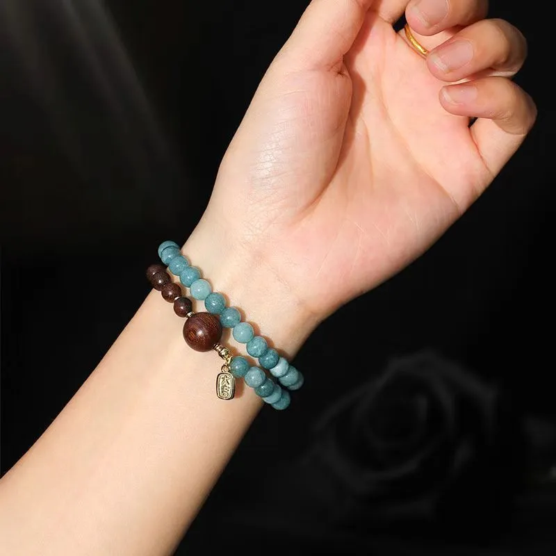 Close-up of a blue electroplated women's beaded bracelet with geometric and Fu/Xi character charms in New Chinese style.