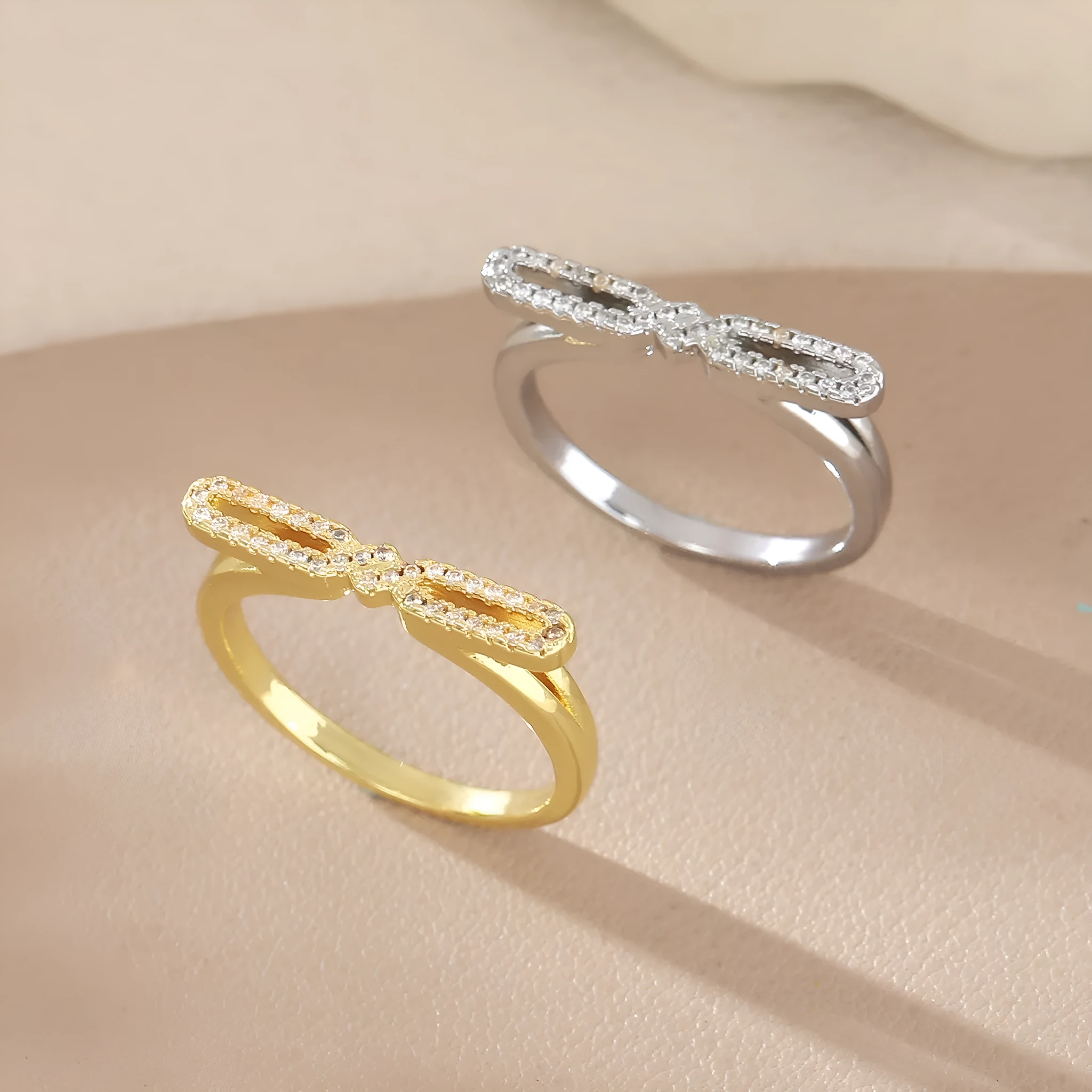 Fashion bowknot ring for women, copper with electroplated gold finish, bow shape on white background