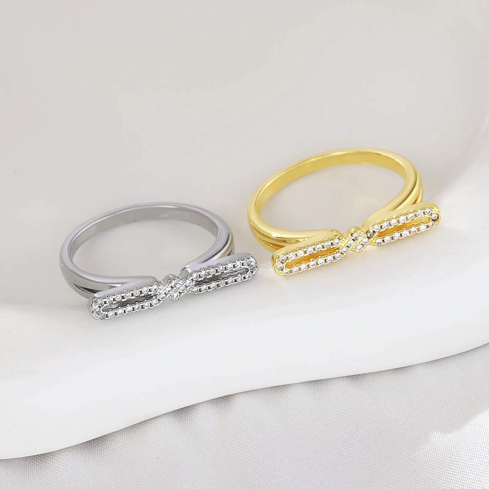 Fashion bowknot ring for women, copper with electroplated gold finish, bow shape on white background