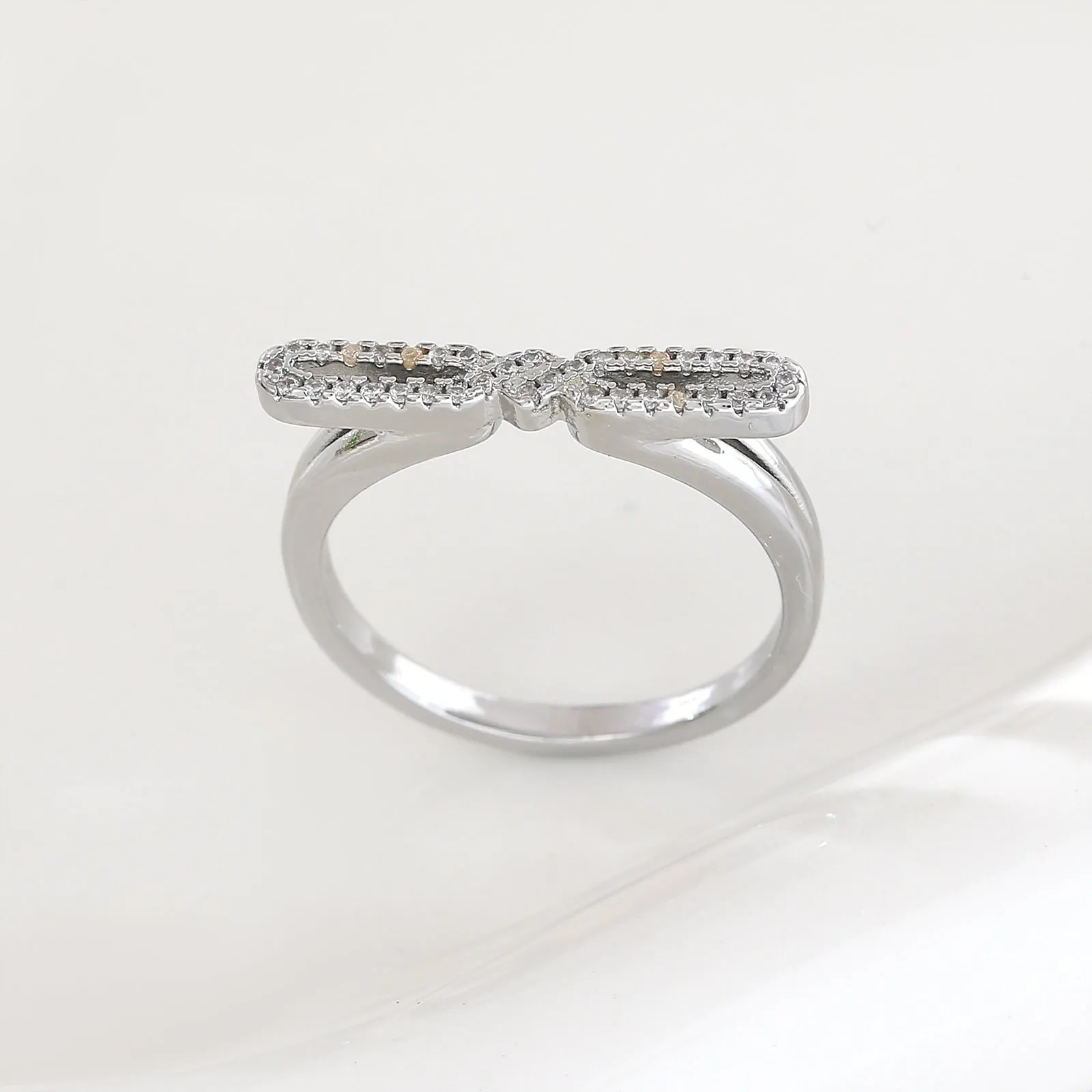 Fashion bowknot ring for women, copper with electroplated gold finish, bow shape on white background