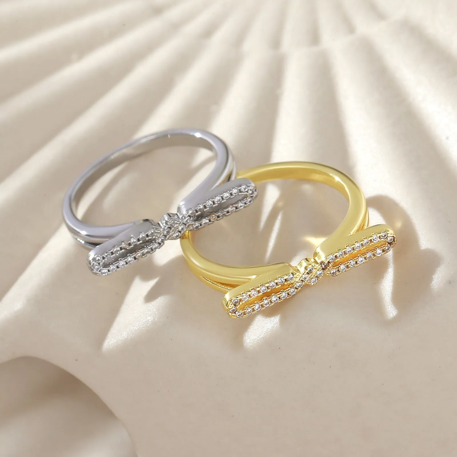 Fashion bowknot ring for women, copper with electroplated gold finish, bow shape on white background