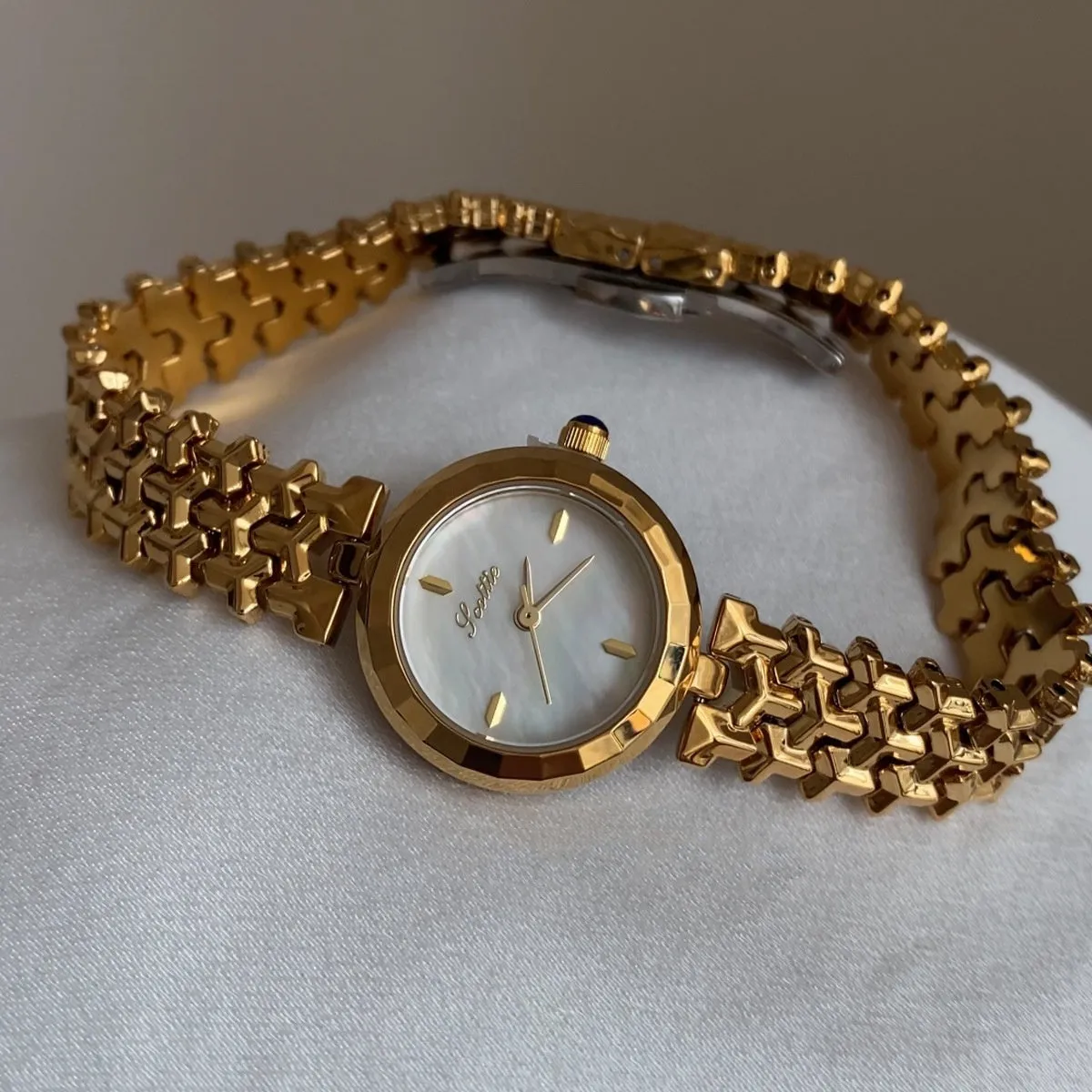 Women's thin 8mm alloy watch with white shell dial and gold strap on wrist