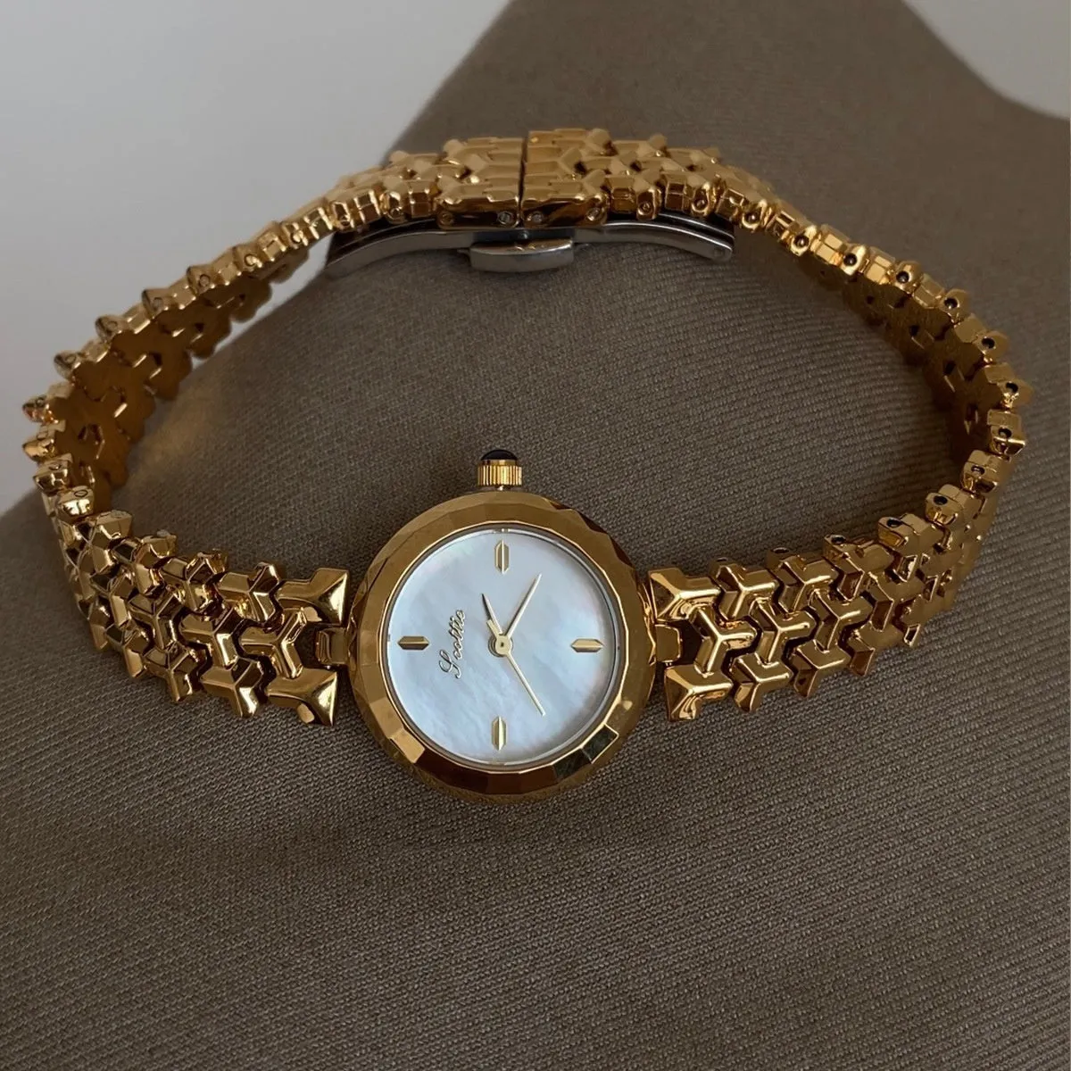 Women's thin 8mm alloy watch with white shell dial and gold strap on wrist