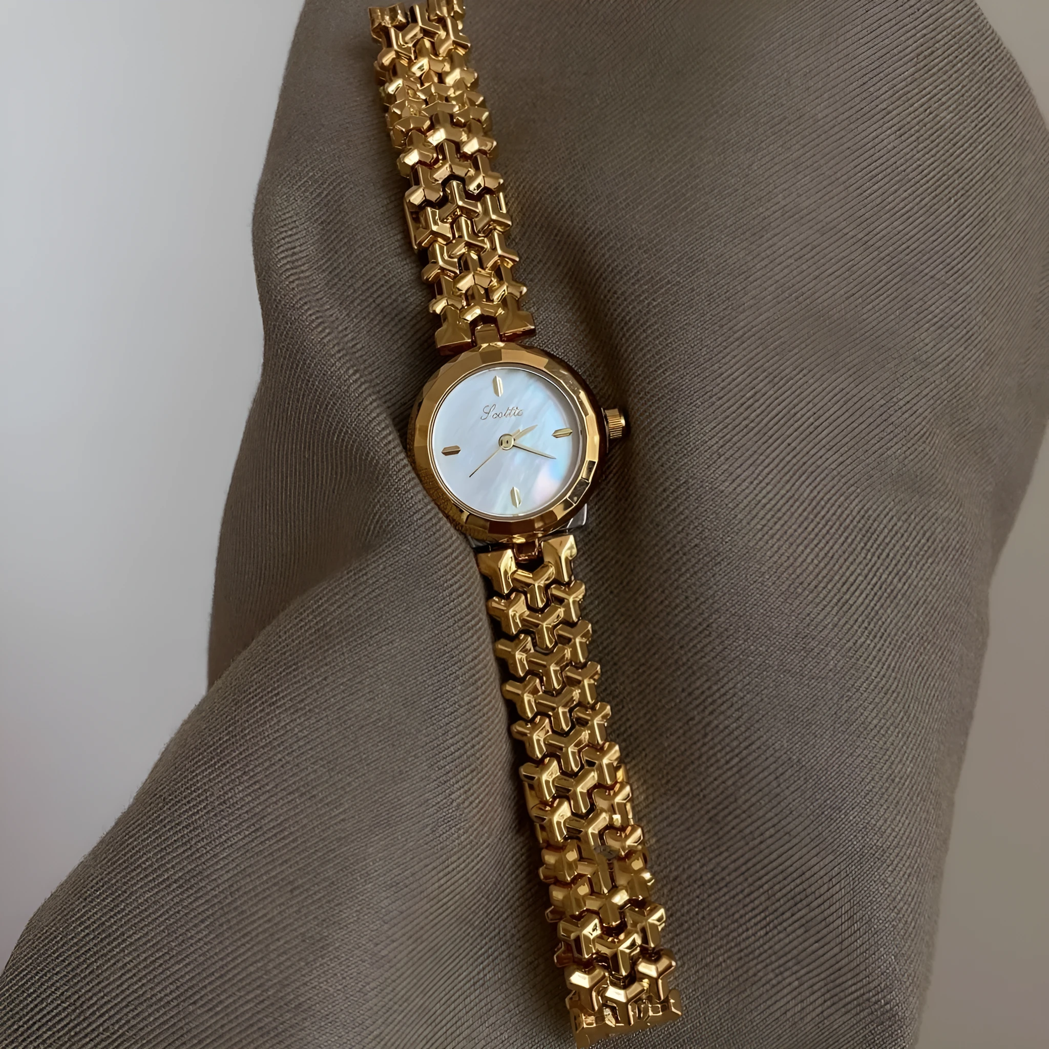 Women's thin 8mm alloy watch with white shell dial and gold strap on wrist