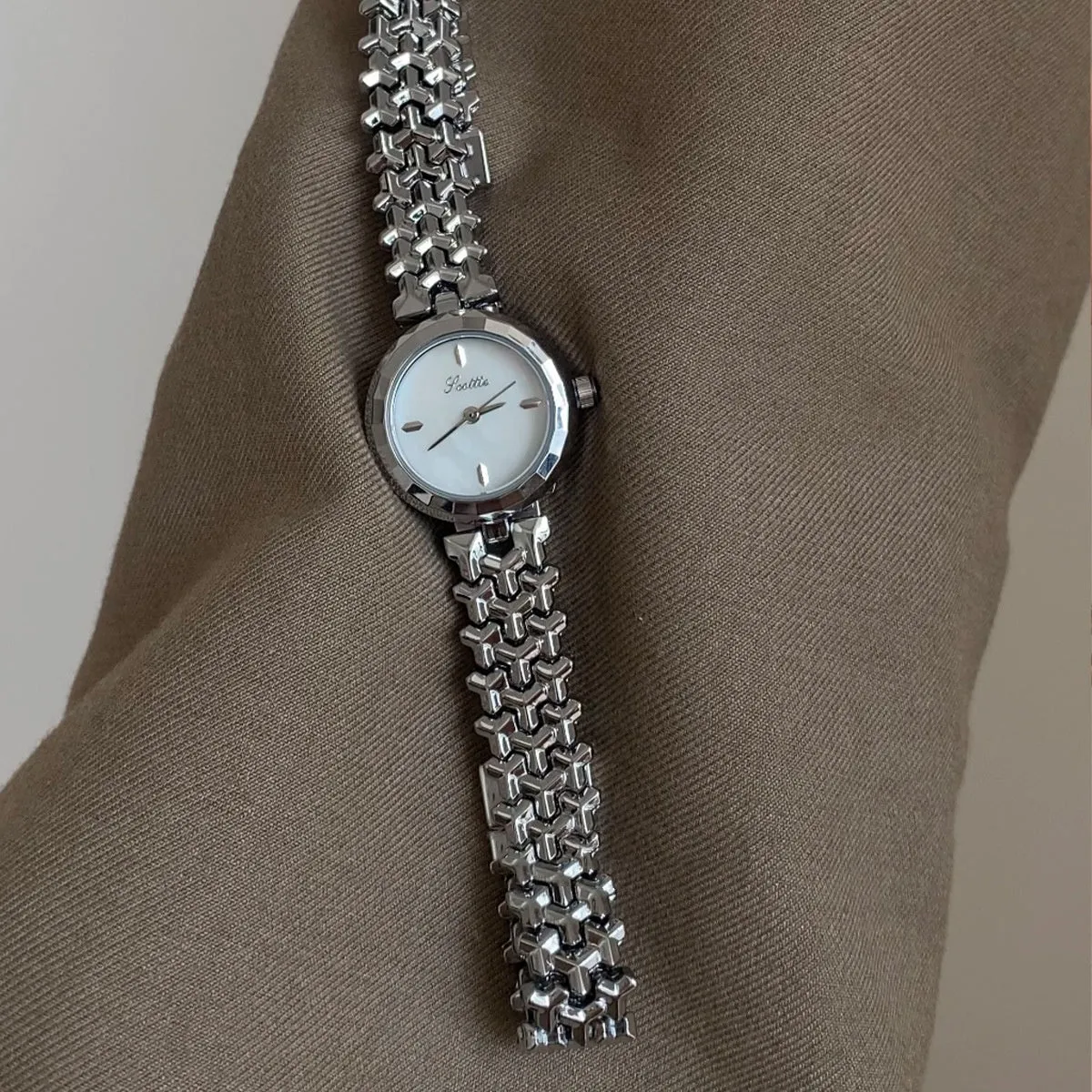 Women's thin 8mm alloy watch with white shell dial and gold strap on wrist