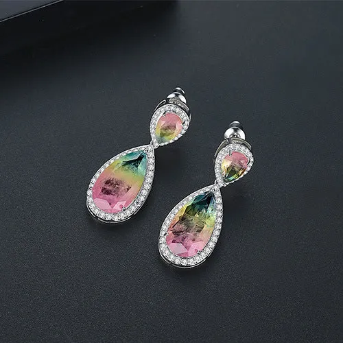 Drop shape copper earrings with inlaid synthetic gemstone in blue colour option on a white background