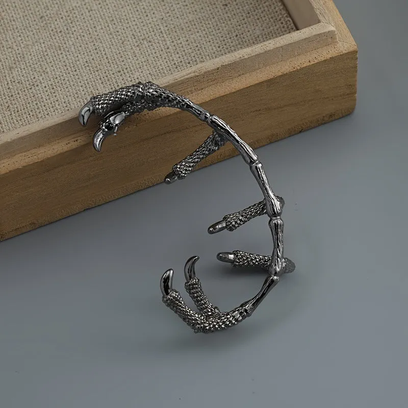 Black copper ear studs with street punk style electroplated finish on a plain background