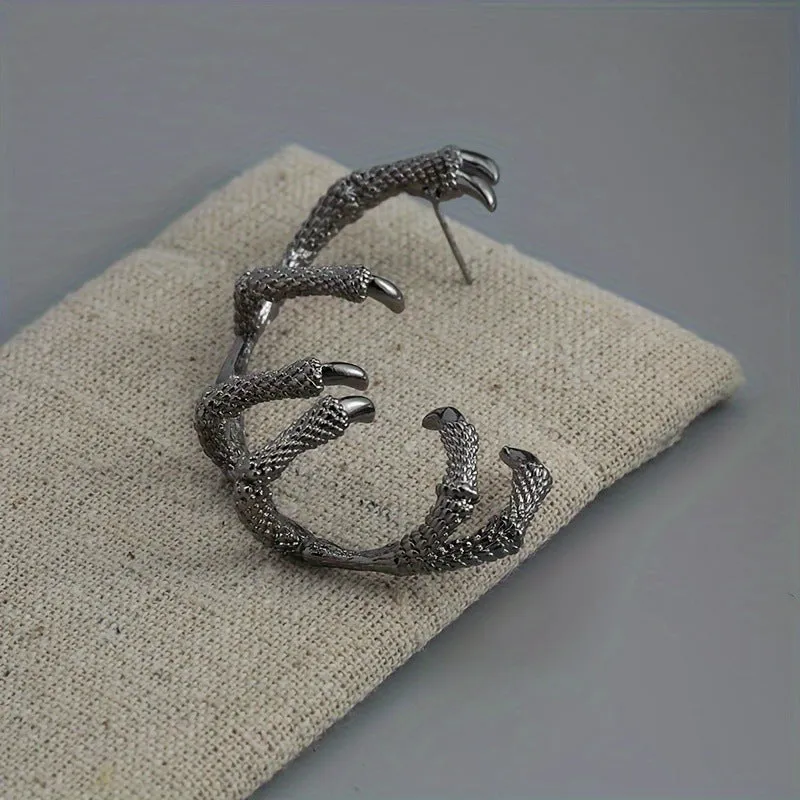 Black copper ear studs with street punk style electroplated finish on a plain background