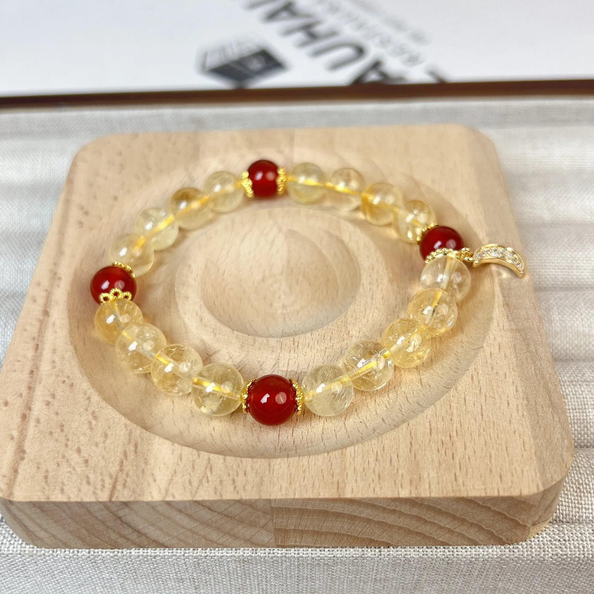 Women's crystal boom bracelet featuring citrine stone, red agate, and central moon design