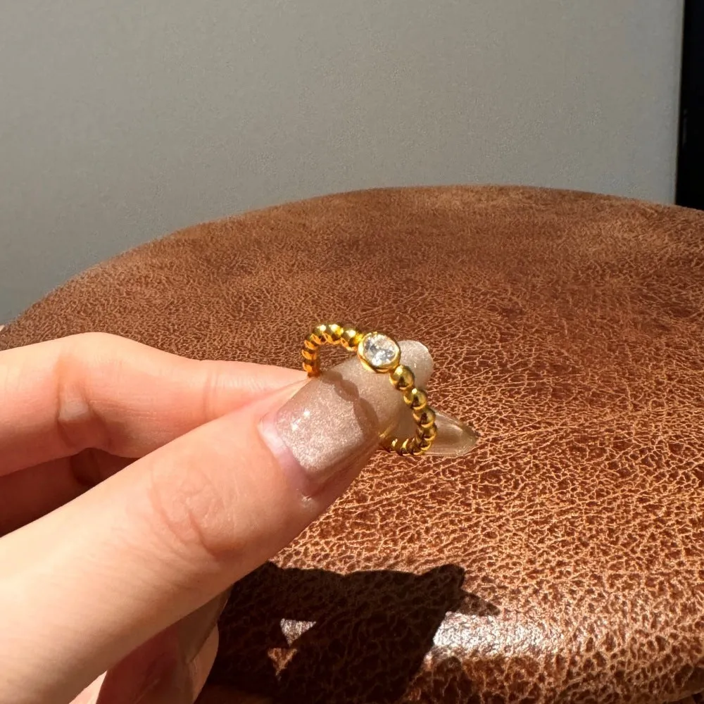 S925 sterling silver ring for women with gold wave bead design and geometric polka-dot pattern on white background