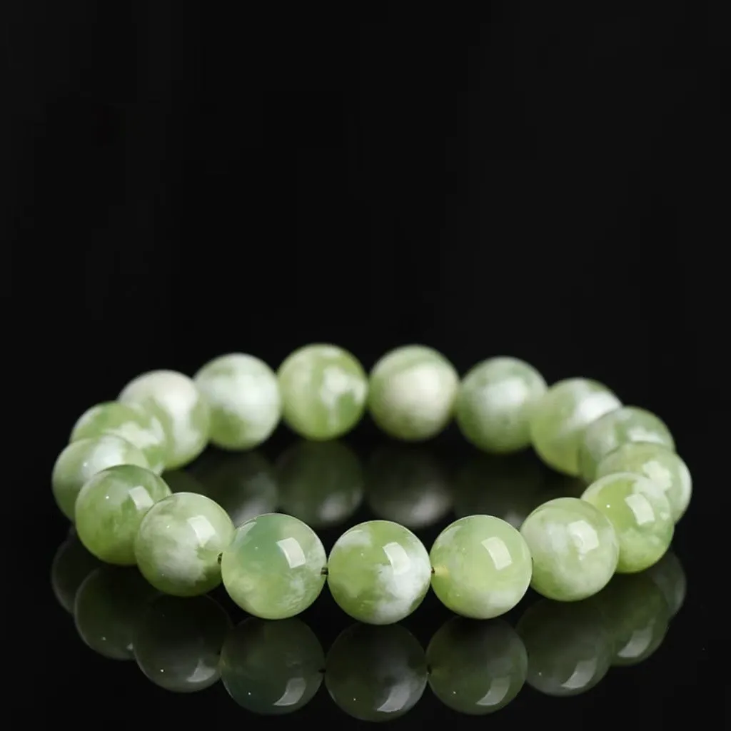 Green milk-in-water Xiuyan jade bracelet with geometric beads on white background