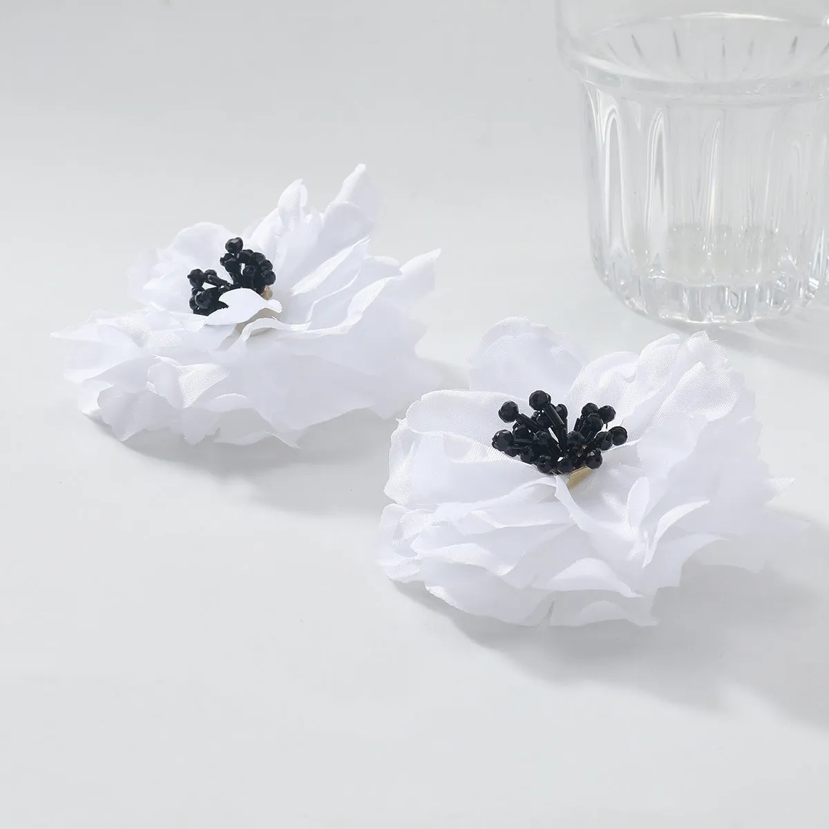 Hand-woven white plastic resin flower earrings for women fashion OL style on display