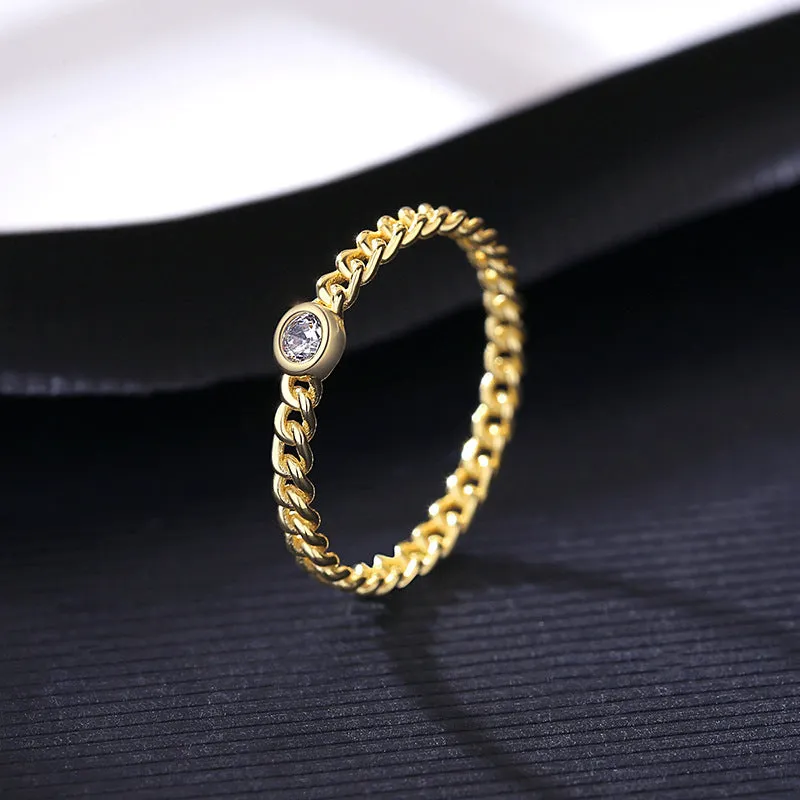 Close-up of 925 silver twist gold ring with geometric chain detail on a neutral background