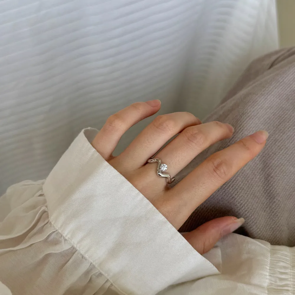 Women's silver electroplated open ring with single diamond and smooth wave line design, white gold tone