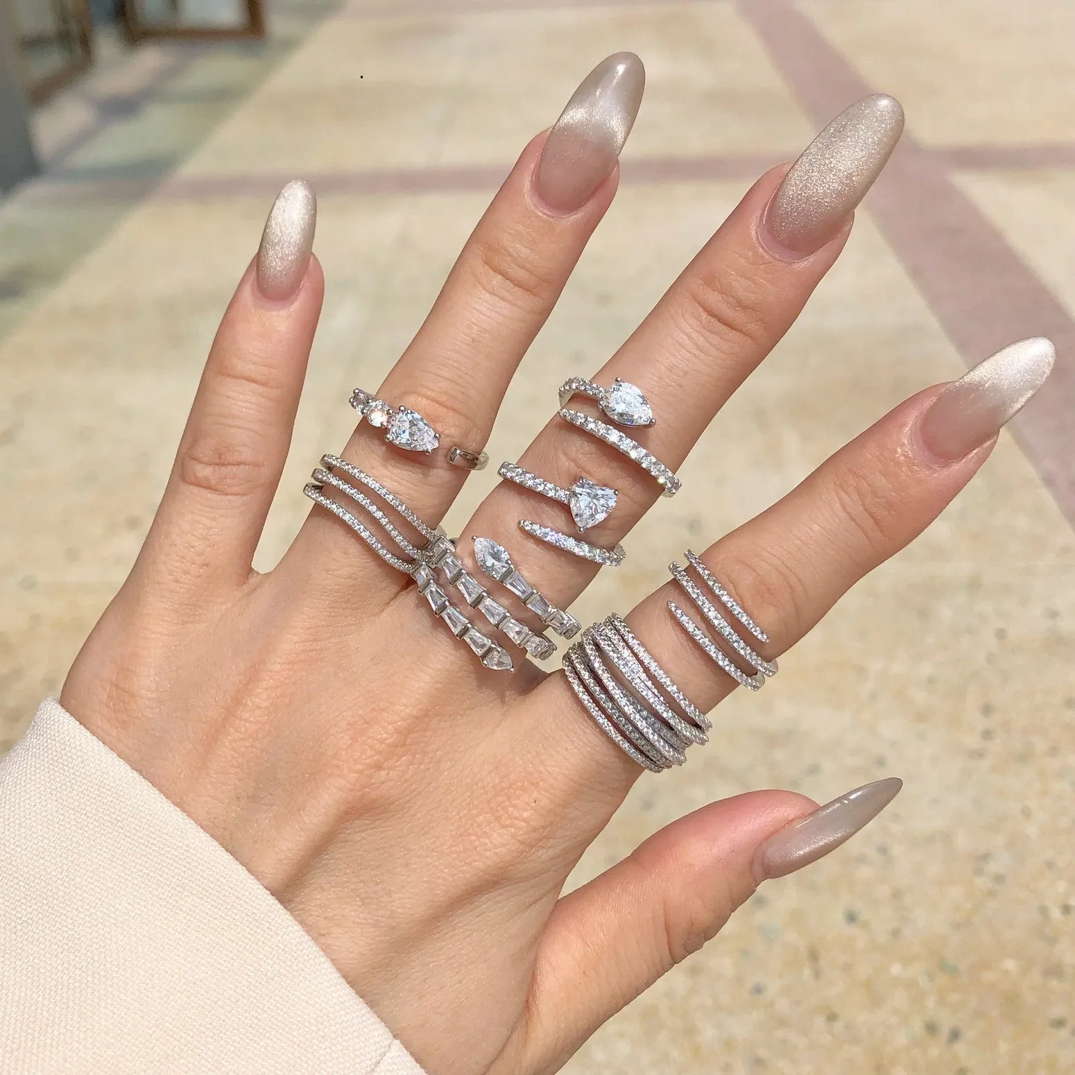 Silver ring with round zircon inlay, platinum colour, sits on a flat surface, side view