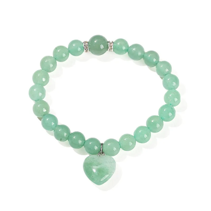 Natural stone love heart pendant bracelet on wrist, showing Tigereye, crystal or aventurine beads.