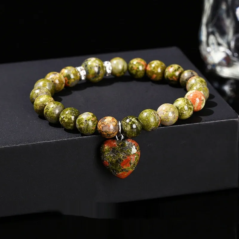 Natural stone love heart pendant bracelet on wrist, showing Tigereye, crystal or aventurine beads.
