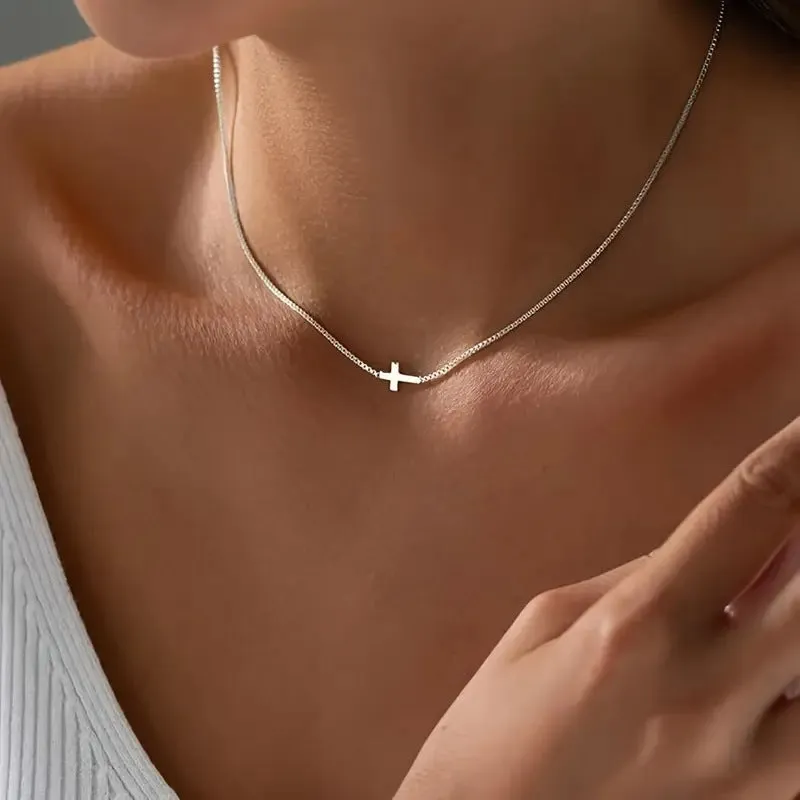 Miniature cross pendant necklace for women in alloy, dainty style on display