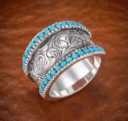 Silver bubble ring with eight-leaf green agate stone on a plain background
