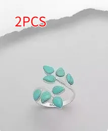 Silver bubble ring with eight-leaf green agate stone on a plain background