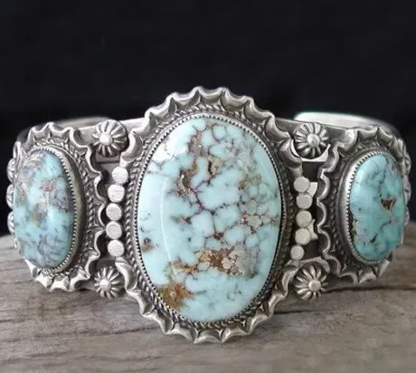 Silver bubble ring with eight-leaf green agate stone on a plain background