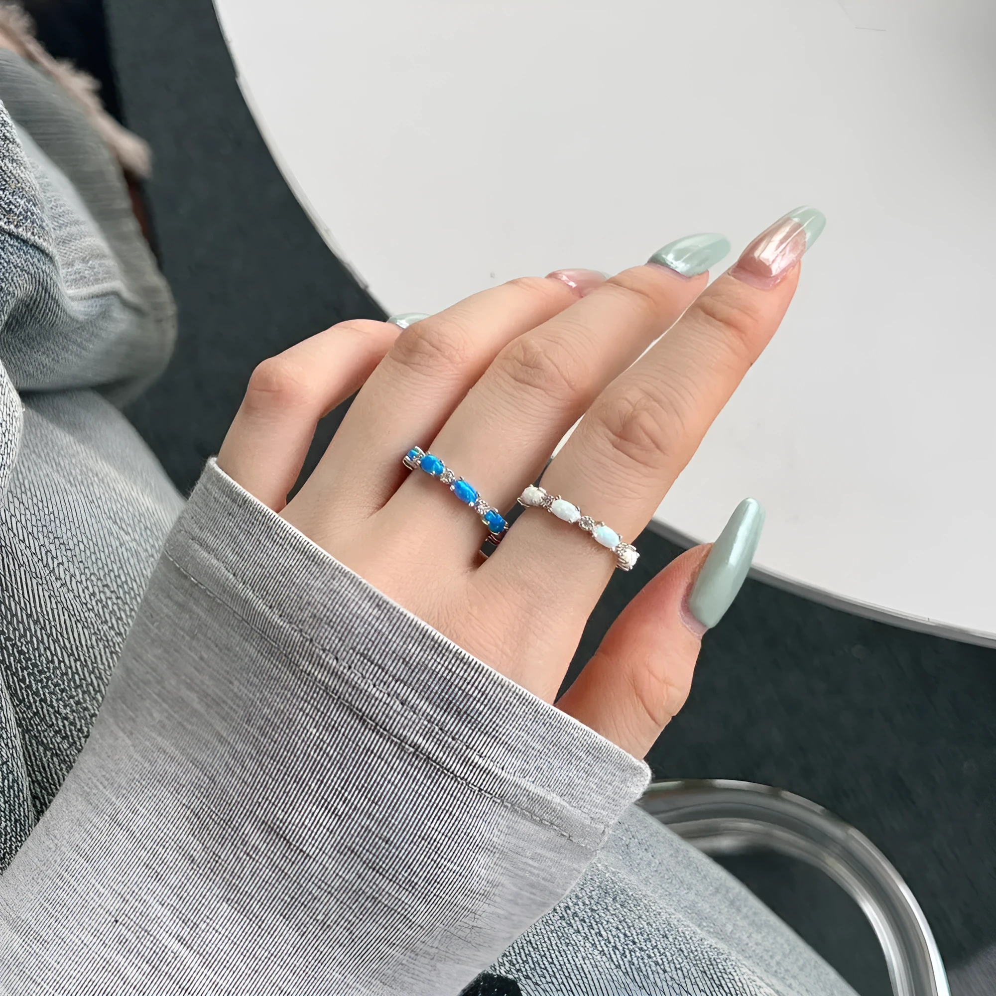S925 sterling silver U-shaped opal ring with electroplated finish in opal blue, side view on white background
