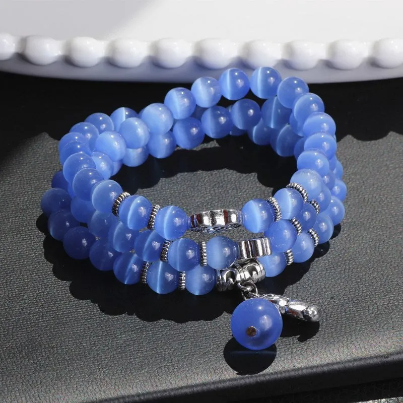 Opal cat eye bracelet with three geometric rings and lucky cat charms on adjustable 52cm cord