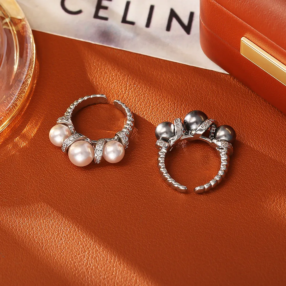 Real gold plated copper open-end ring with round pearl in geometric setting, grey colour, on a neutral background