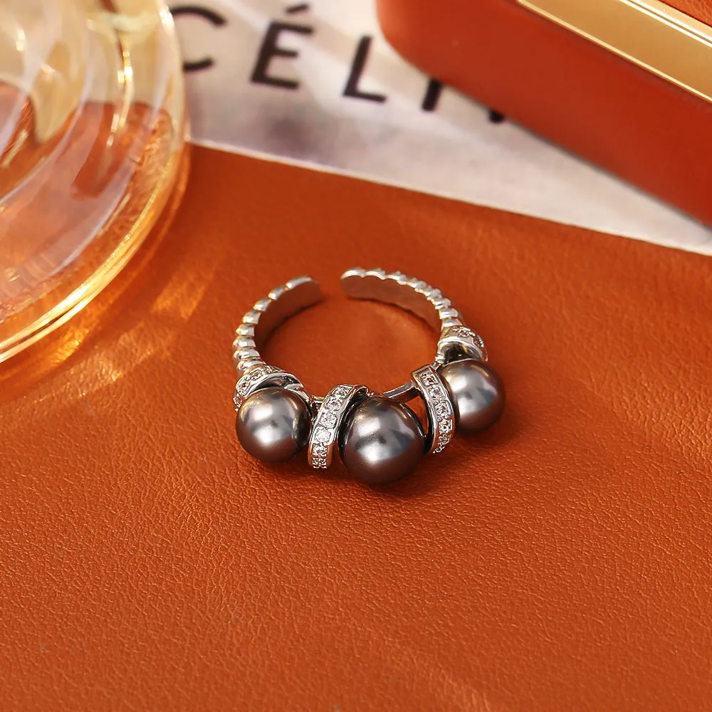 Real gold plated copper open-end ring with round pearl in geometric setting, grey colour, on a neutral background