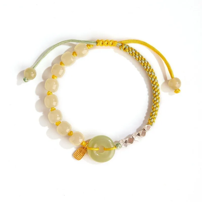 Woven bracelet with a natural Hetian jade flower charm and safety buckle in maple leaf yellow.